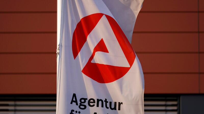 Eine Fahne mit dem Logo der Agentur für Arbeit weht.
