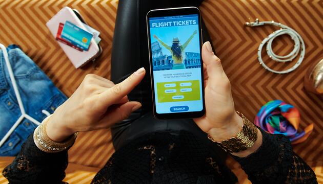 Frau bucht Flug am Handy