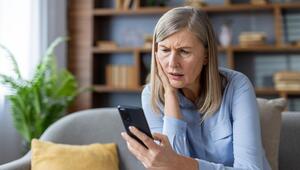 Fra schaut erschrocken aufs Handy