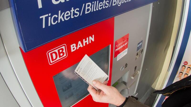 Ein Fahrgast kauft ein Ticket am Automaten