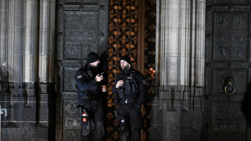 Polizisten sichern einen Eingang zum Kölner Dom.