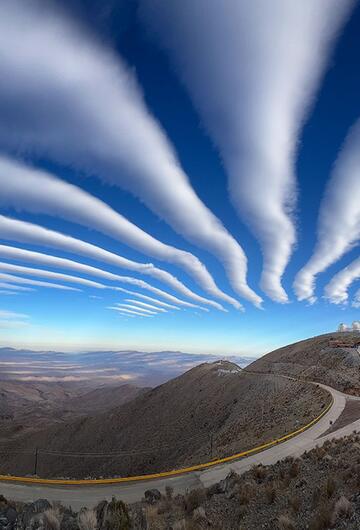 Dünne Wolken zeigen auf die Spitze eines Hügels.