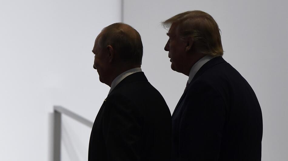 Donald Trump und Wladimir Putin laufen nebeneinander durch ein Gebäude