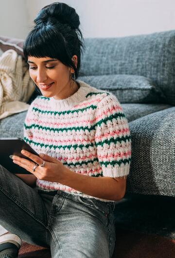 Junge Frau vergleicht Preise auf ihrem Tablet.