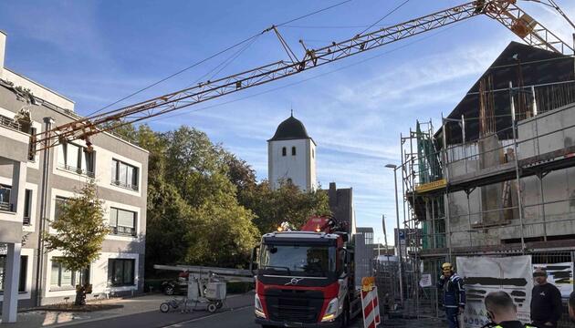Kran kippt und stürzt auf Wohnhaus