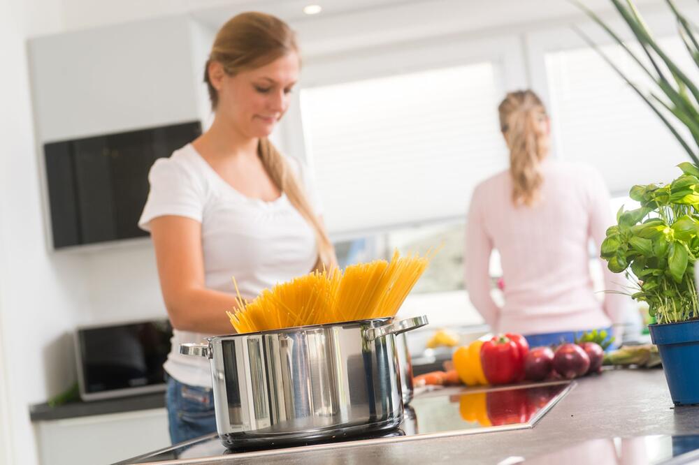 Zwei Frauen kochen Spaghetti in Küche