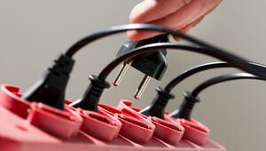 Ein Mann zieht einen Stecker aus einer Steckerleiste