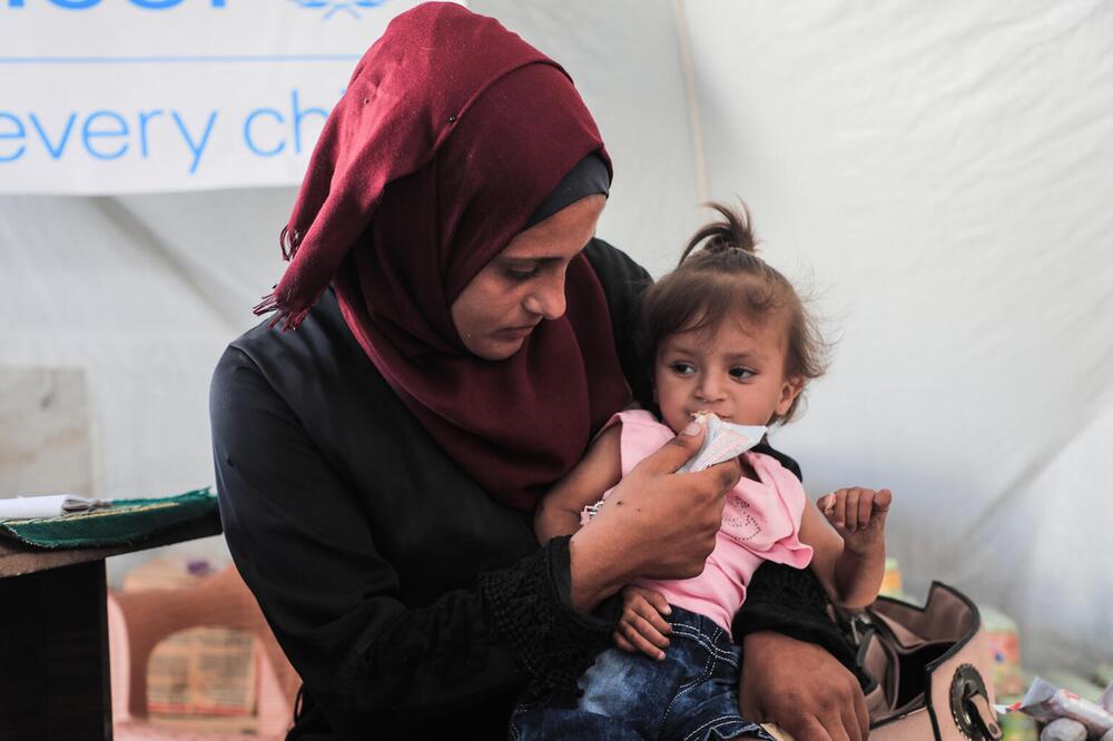 Eine Mutter füttert ihr Kind mit therapeutischer Zusatznahrung.