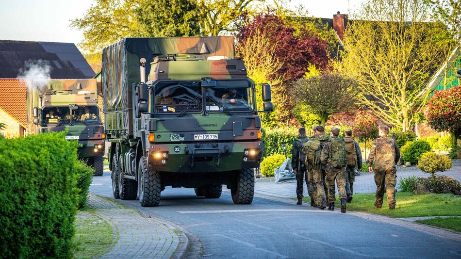 Einsatzkräfte der Bundeswehr laufen durch den Wohnort des vermissten Arian