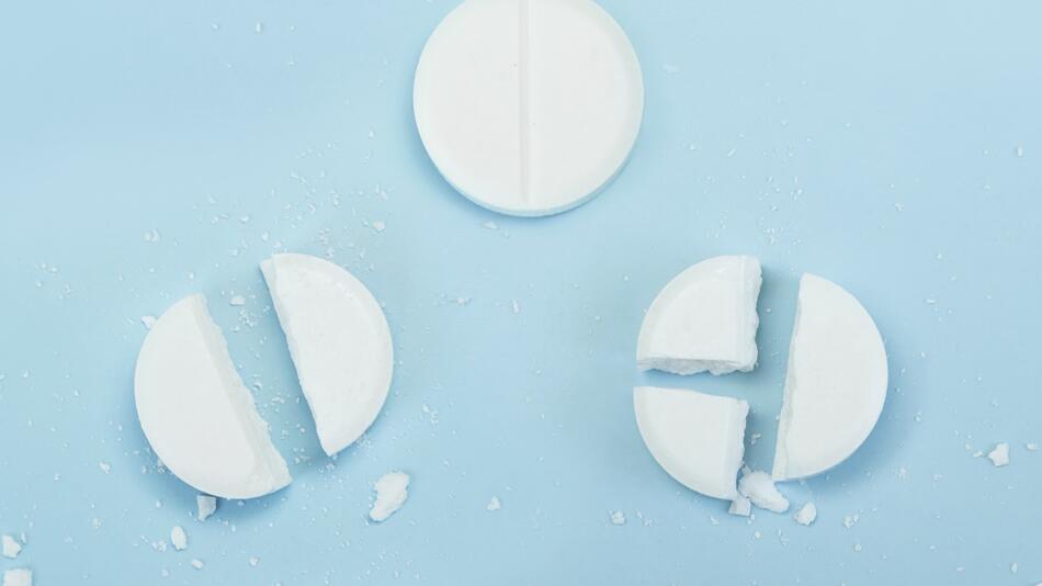 Geteilte Tabletten auf blauem Hintergrund
