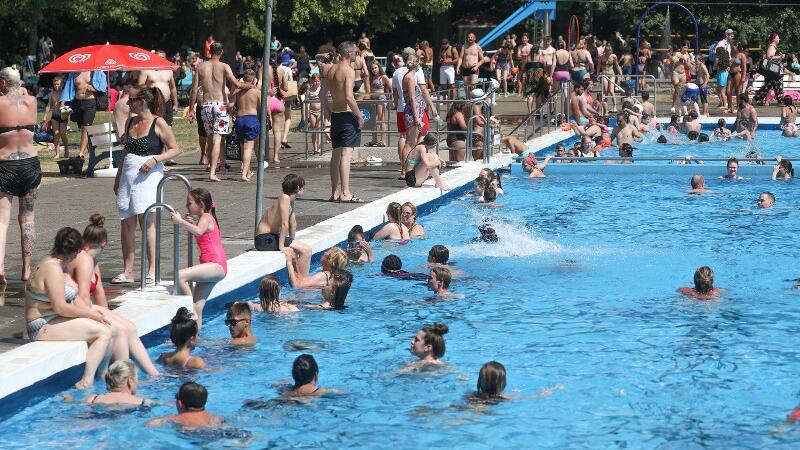 Im Freibad tummeln sich viele Menschen bei der Hitze.