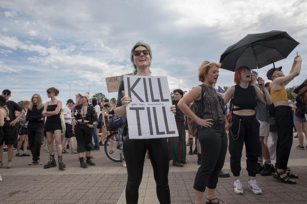 Frau hält ein Schild mit der Aufschrift "Kill Till"