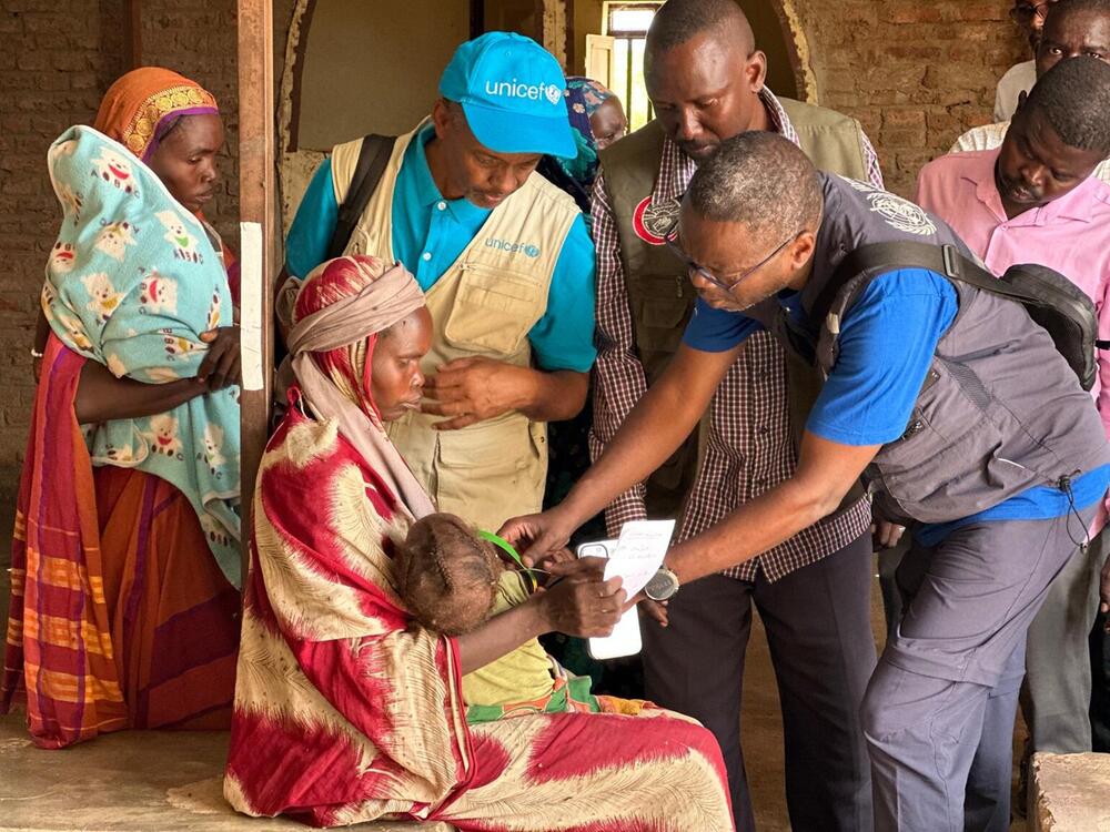 UNICEF Mitarbeiter kümmern sich um ein Kind und seine Mutter