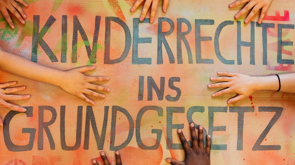 Kinderhände auf einem Plakat auf dem steht: Kinderrechte ins Grundgesetz