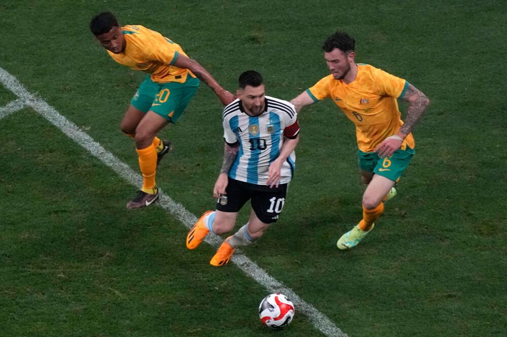 Argentiniens Lionel Messi setzt sich am 15. Juni 2023 in Peking gegen zwei Australier durch
