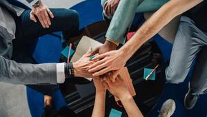 Gruppe Kolleginnen und Kollegen legen die Hände aufeinander