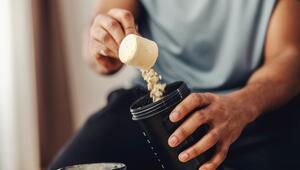 Mann füllt Proteinpulver in einen Shaker