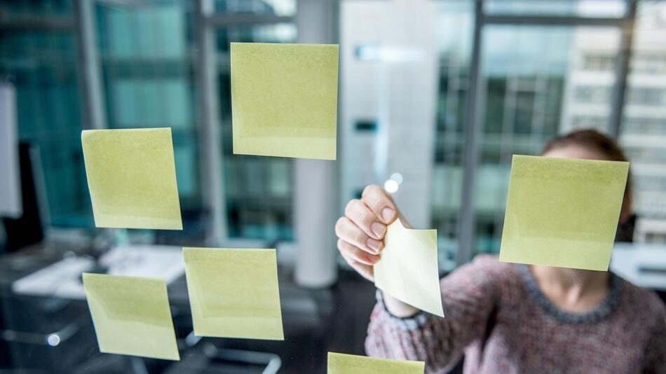 Post-its kleben an einer Scheibe in einem Büro