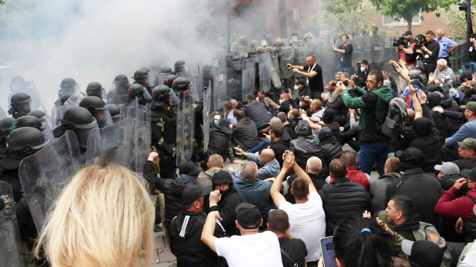 Links eine Polizeiblockade, rechts serbische Demonstranten