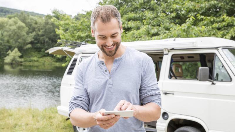 Ein Camper mit Smartphone