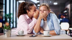 Junge Frauen lachen im Café und Flüstern