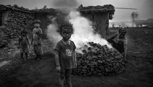 Kleine Kinder vor brennender Kohle