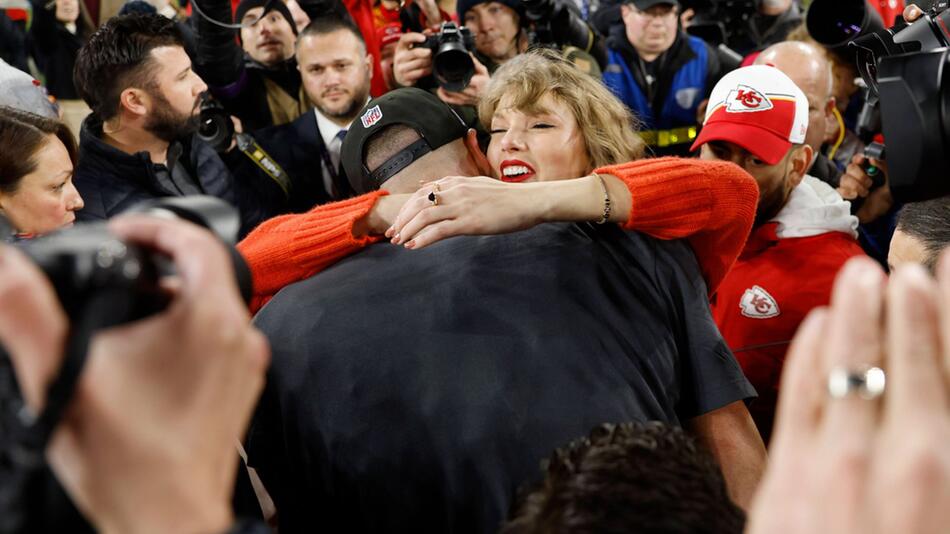 Süßer Moment inmitten der Massen: Nach dem Sieg gegen die Baltimore Ravens fallen sich Taylor ...