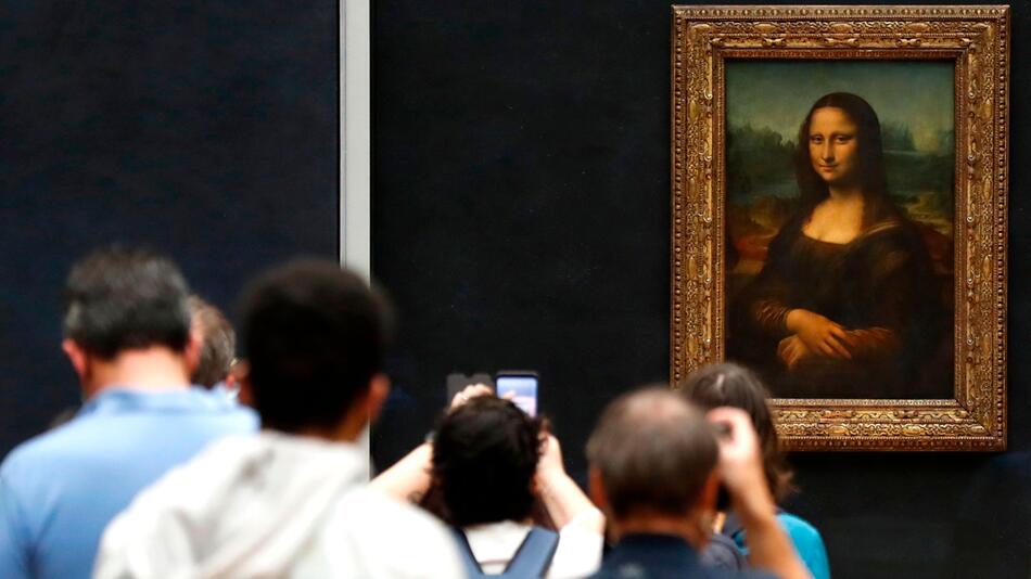 Besucher machen Fotos vor Leonardo da Vincis Meisterwerk "Mona Lisa" im Louvre-Museum in Paris.