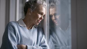 ältere Frau blickt aus dem fenster