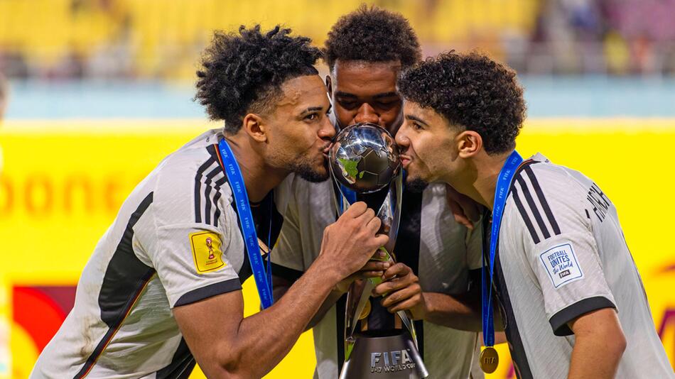 Almugera Kabar, Charles Herrmann und Fayssal Harchaoui (v.l.) küssen den WM-Pokal.