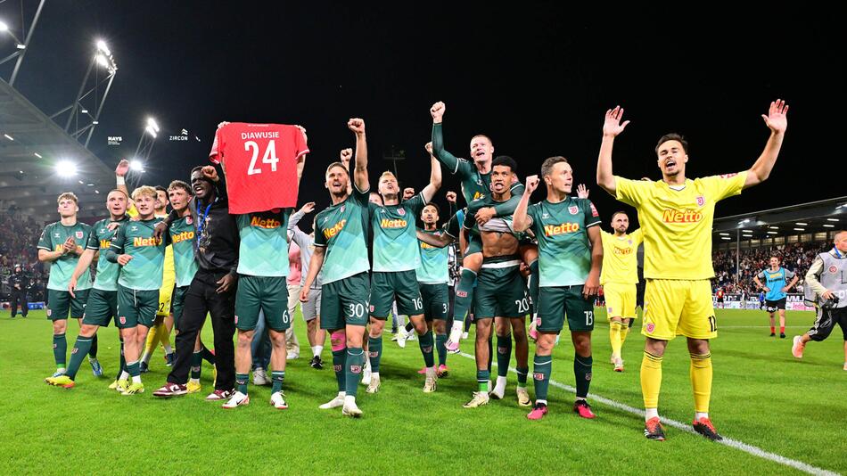 Die Spieler des SSV Jahn Regensburg feiern in Wiesbaden die Rückkehr in die 2.Bundesliga