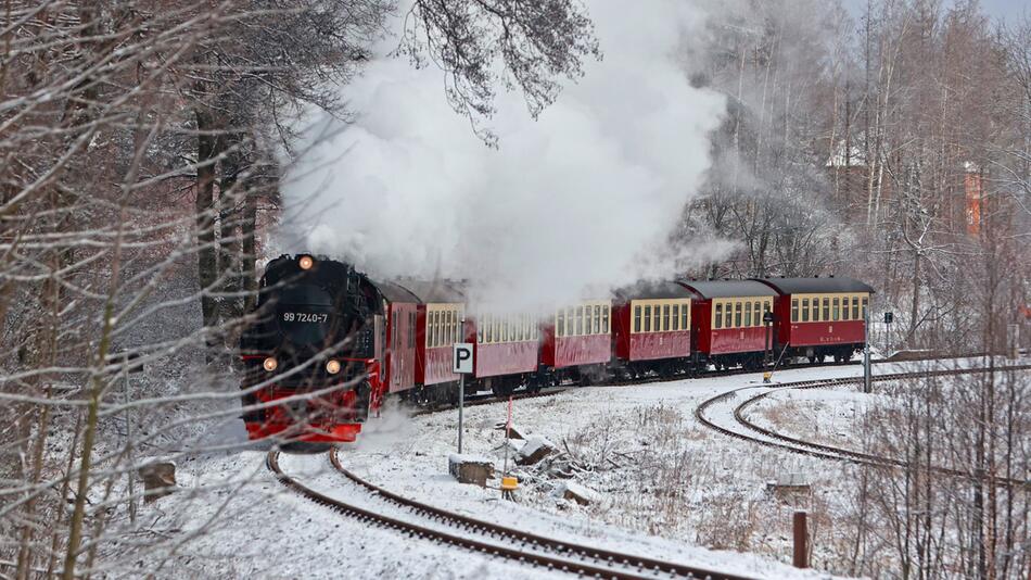 Harzer Schmalspurbahn fährt durch den Schnee.