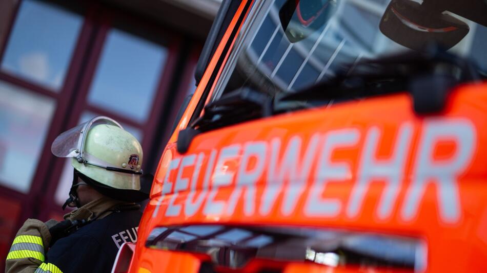 Feuerwehrmann steht neben einem Feuerwehrauto