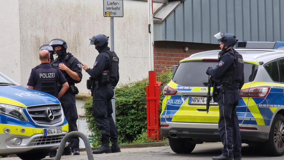 Einsatzkräfte der Polizei warten an einem der Tatorte.