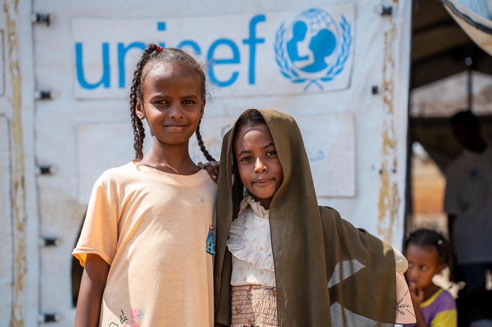 Zwei Mädchen vor einem UNICEF-Zelt