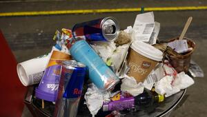 Mehrere Pfanddosen liegen auf einem überfüllten Mülleimer.