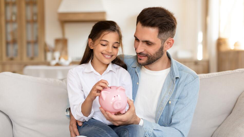 Father teaching daughter about savings