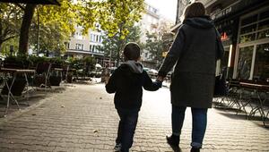 Eine Frau hält ein Kind an der Hand