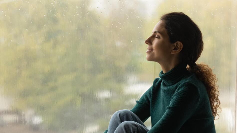 Frau sitzt am Fenster