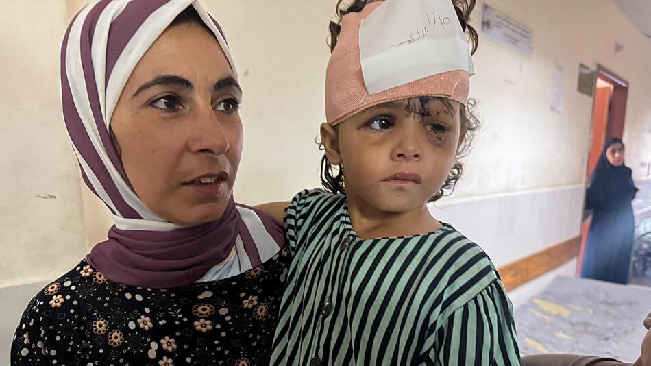 Ein verletztes Kind auf dem Arm der Mutter