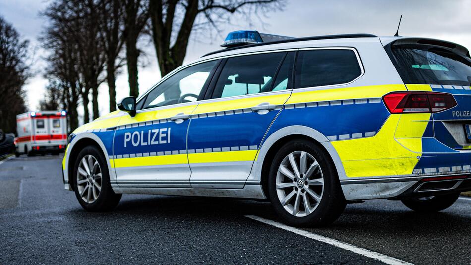 Ein Polizeiauto im Vordergrund und ein Krankenwagen im Hintergrund