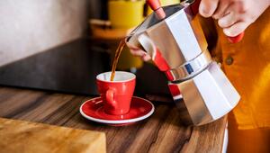 Frau gießt Kaffee in eine rote Tasse