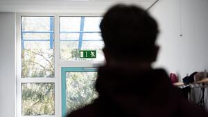 Ein Schüler steht im Flur einer Schule und blickt auf ein Ausgangsschild