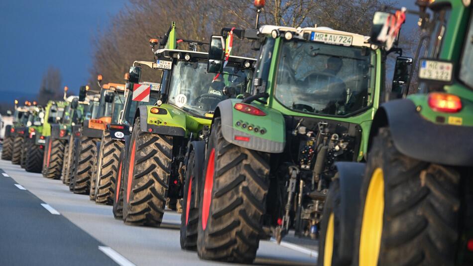 Bauern fahren mit ihren Traktoren im Konvoi auf der Autobahn A66 bei Wiesbaden-Nordenstadt.