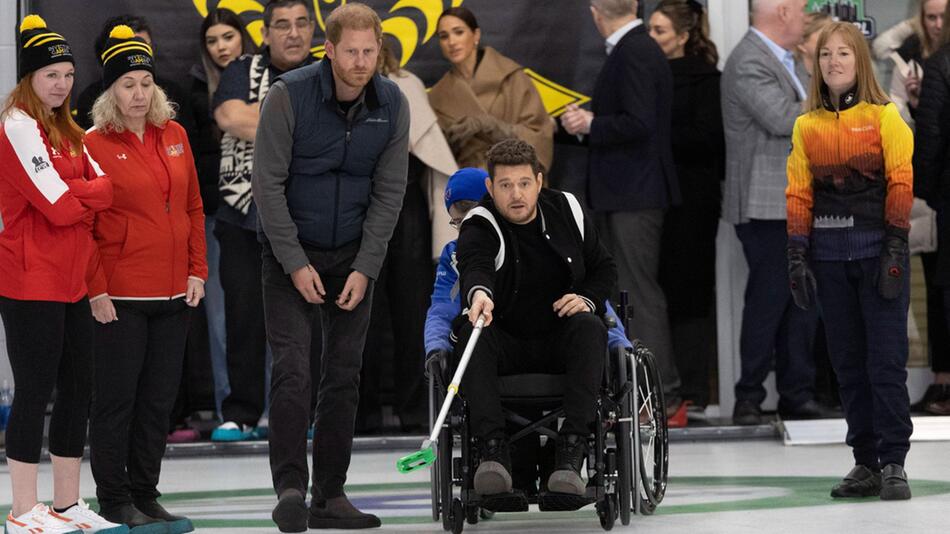 Voller Einsatz: Michael Bublé probierte neben Prinz Harry Rollstuhl-Curling aus. Im Hintergrund ...